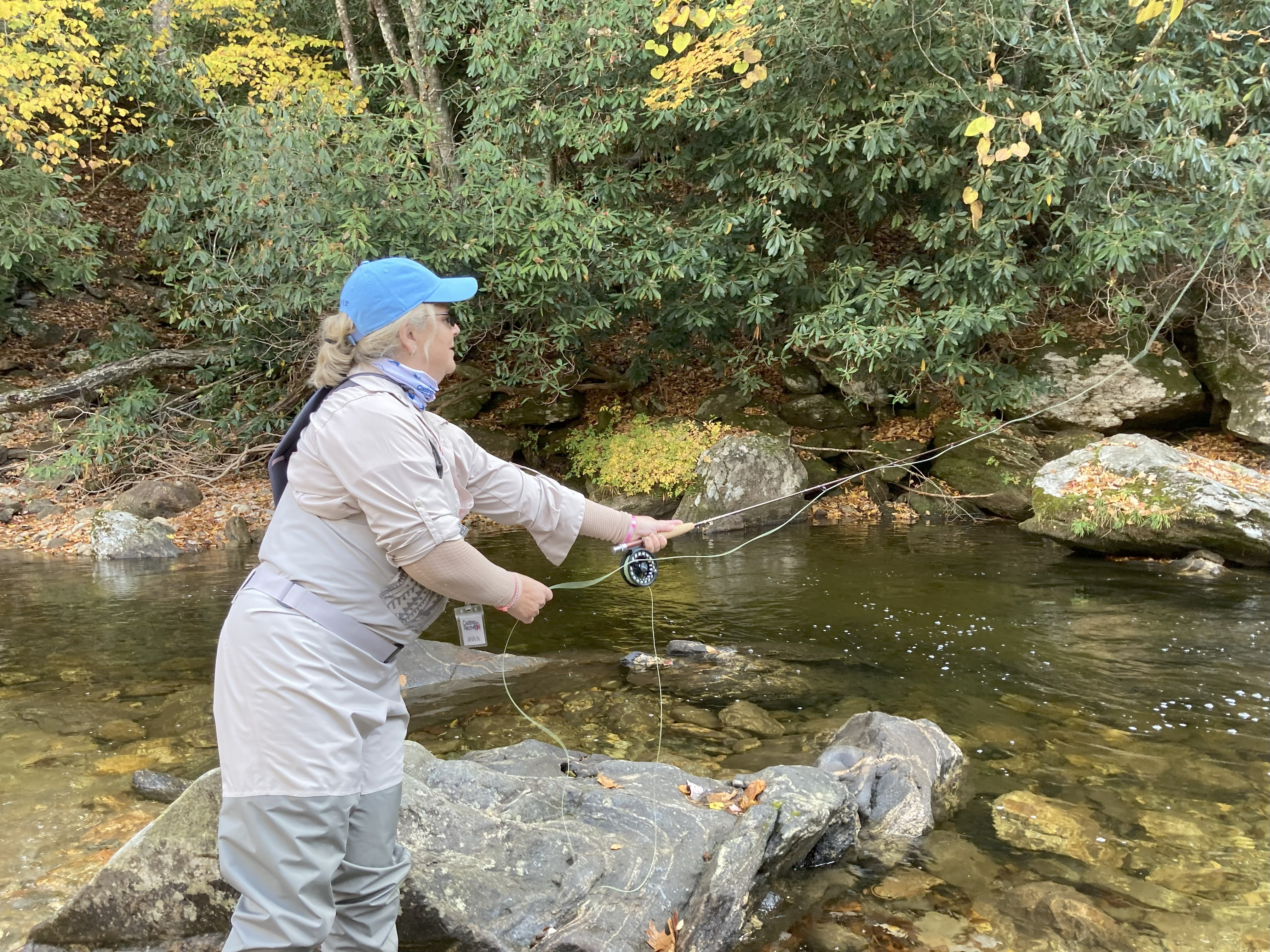 A woman fly fishing.