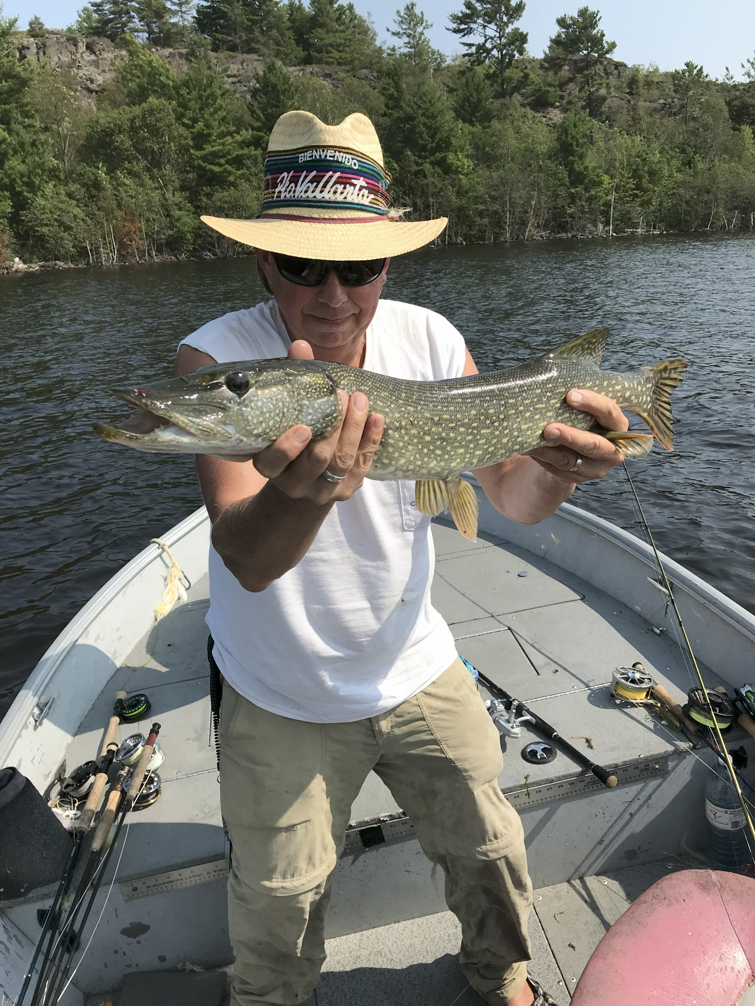 FMan standing in a boat holding the fish he caught.