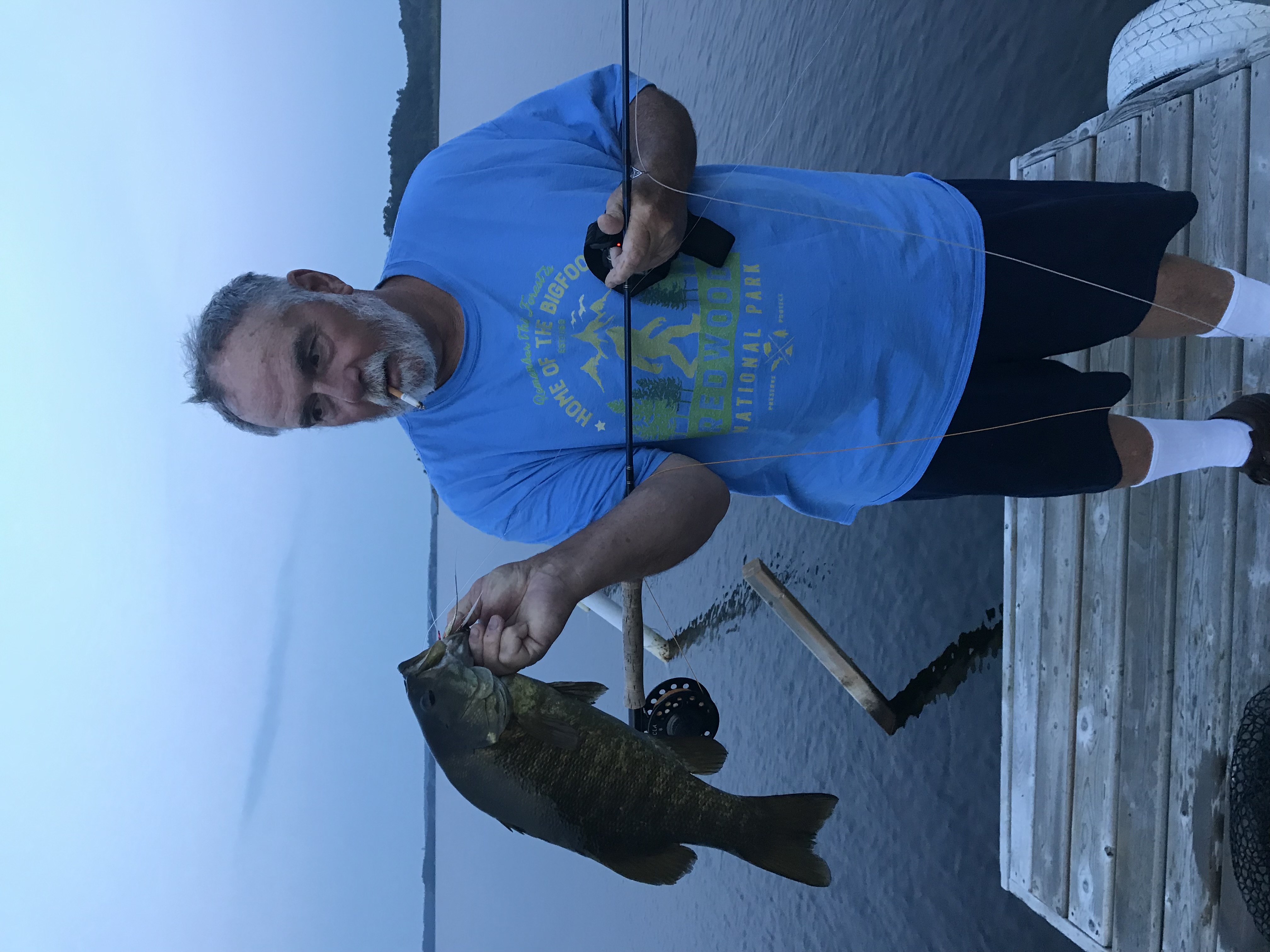 Man holding fish and rod.