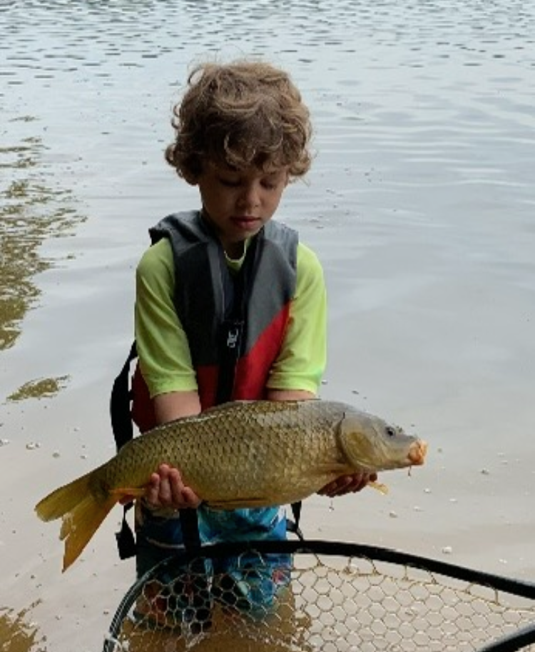 Boy wearing a life jacket holding a fishing.