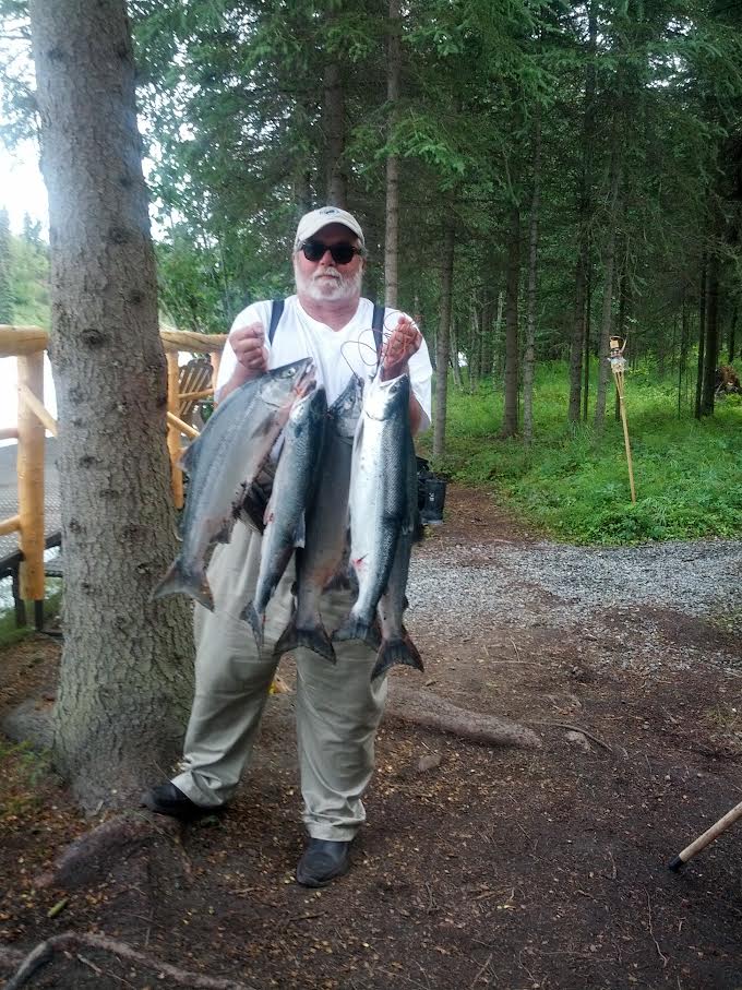 man holding a string of fish.
