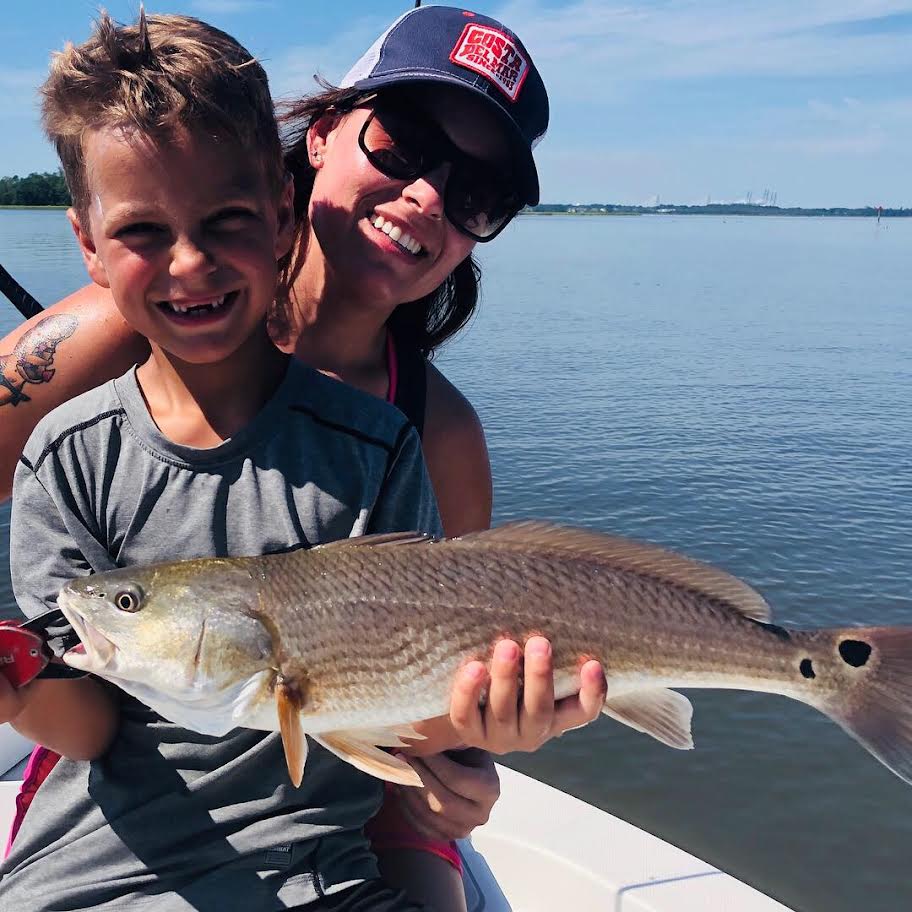Mother and son posing with a fish.