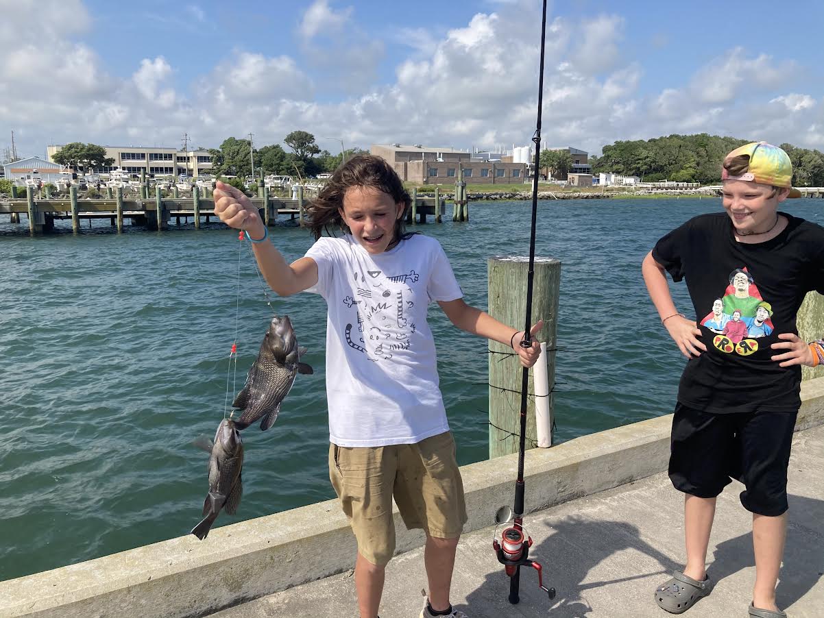 Cousins catching two black bass.