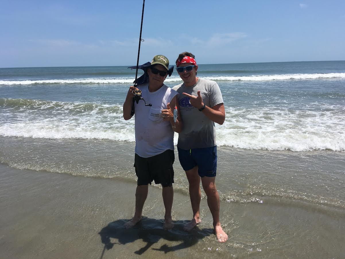 Two men surf fishing.