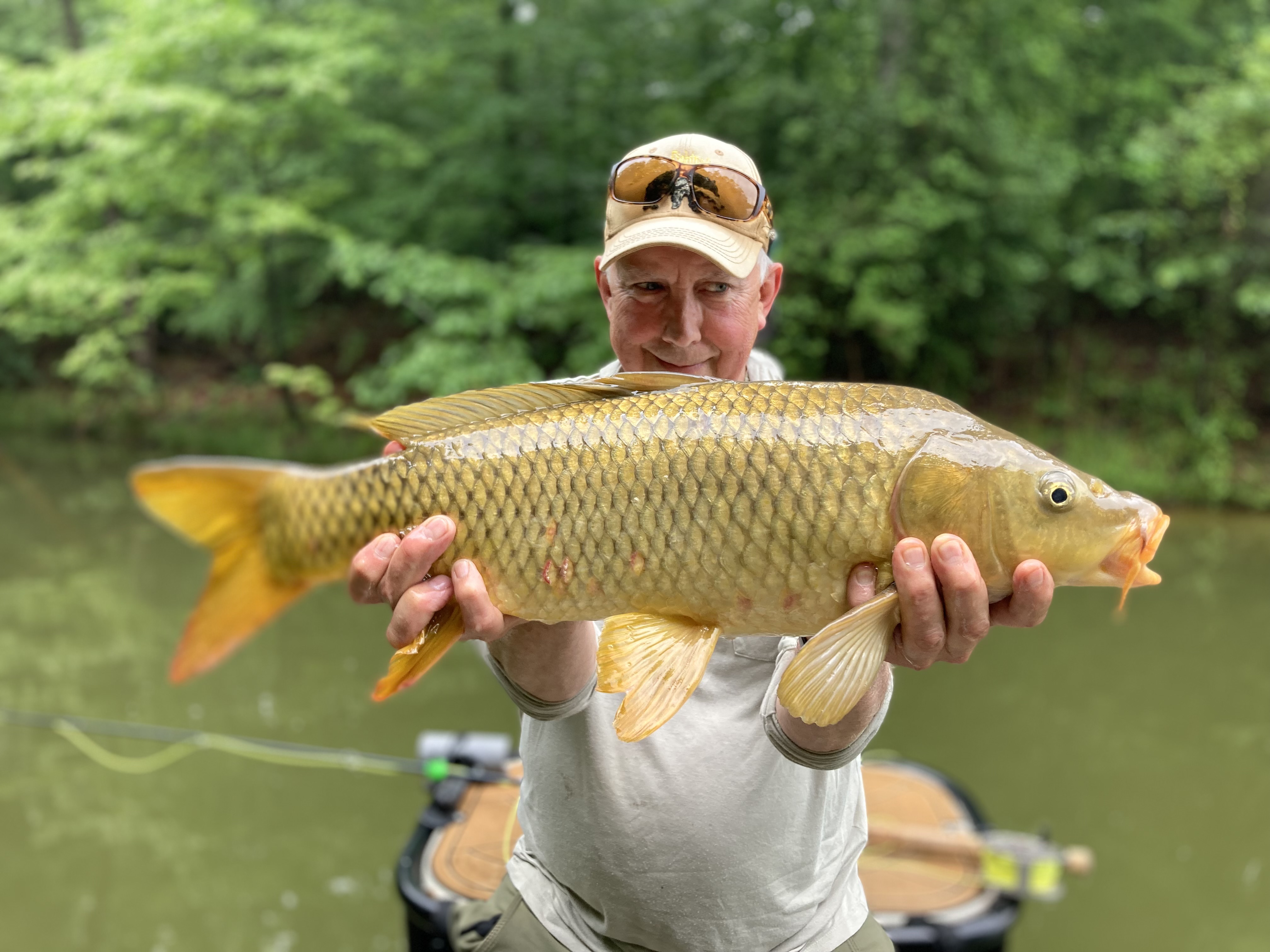 Man holding a golden fish in a canoe.