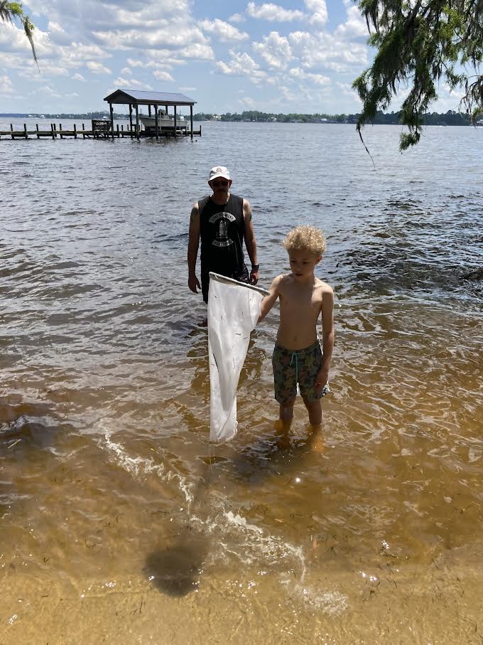 Man and boy with a net in the river.