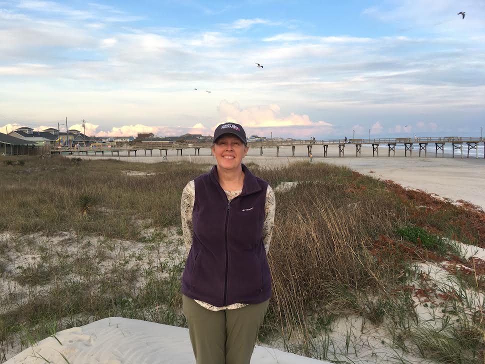 Woman poses at the beach in october.