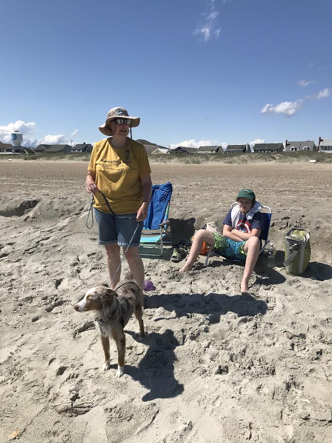 Woman hold a dog at the beach.