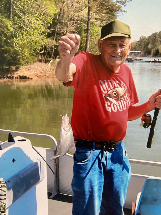 Man holding fish wearing a res shirt.